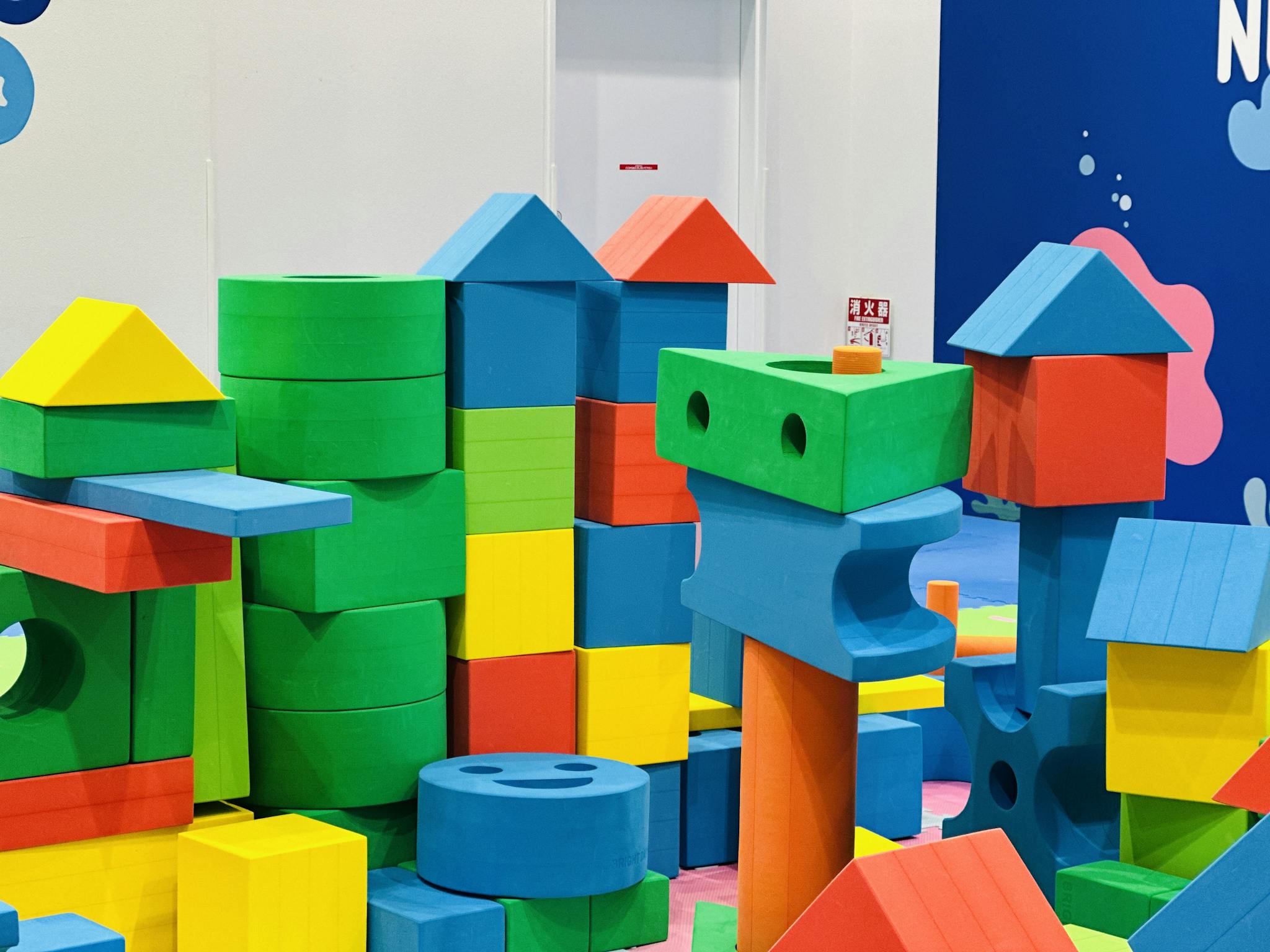 Vibrant foam building blocks stacked in an indoor children's play area.